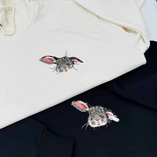 An unisex hoodie/sweatshirt with embroidered images of rabbits on the front.